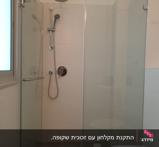 מקלחון פינתי מזכוכית שקופה עם דלת ציר ומוט חיזוק מותקן בחדר רחצה